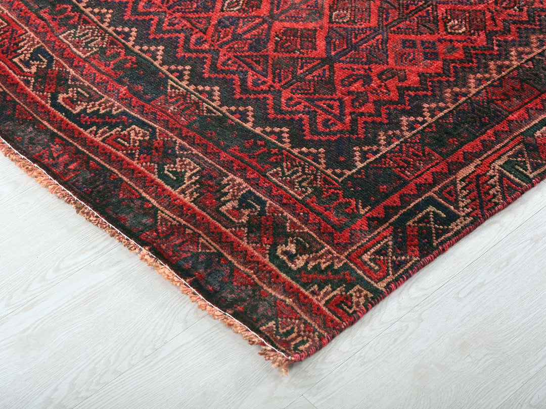 a red and black rug on a white floor