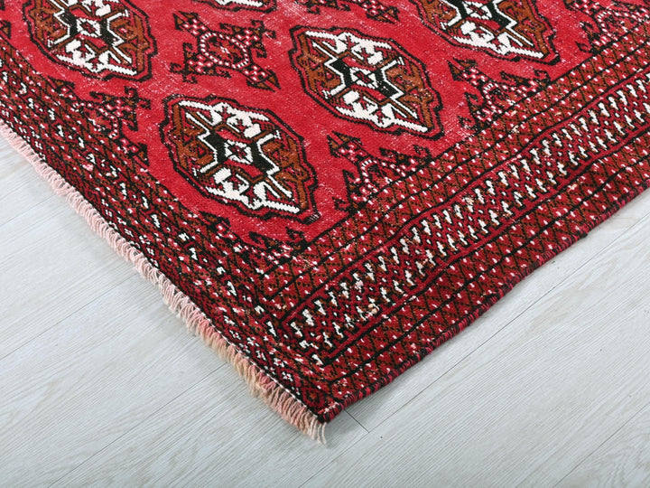 a close up of a red rug on a white floor