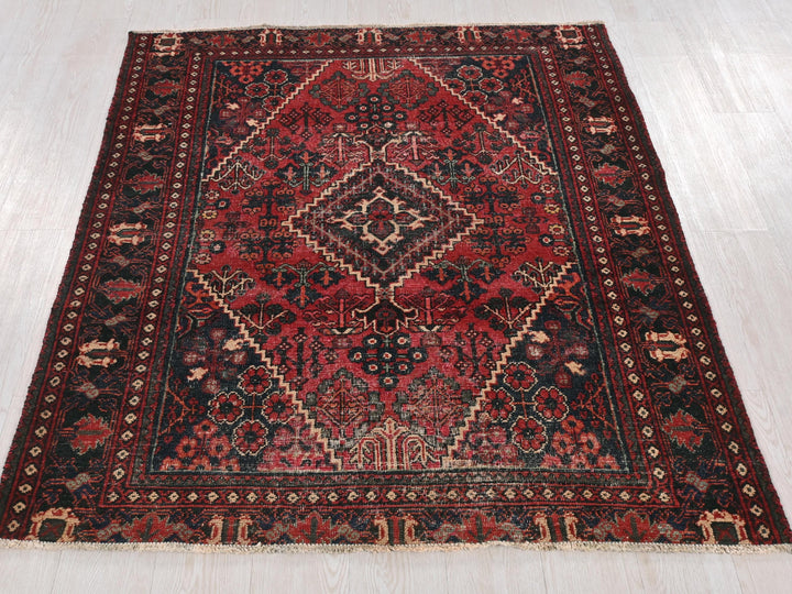 a red and black oriental rug on a white floor