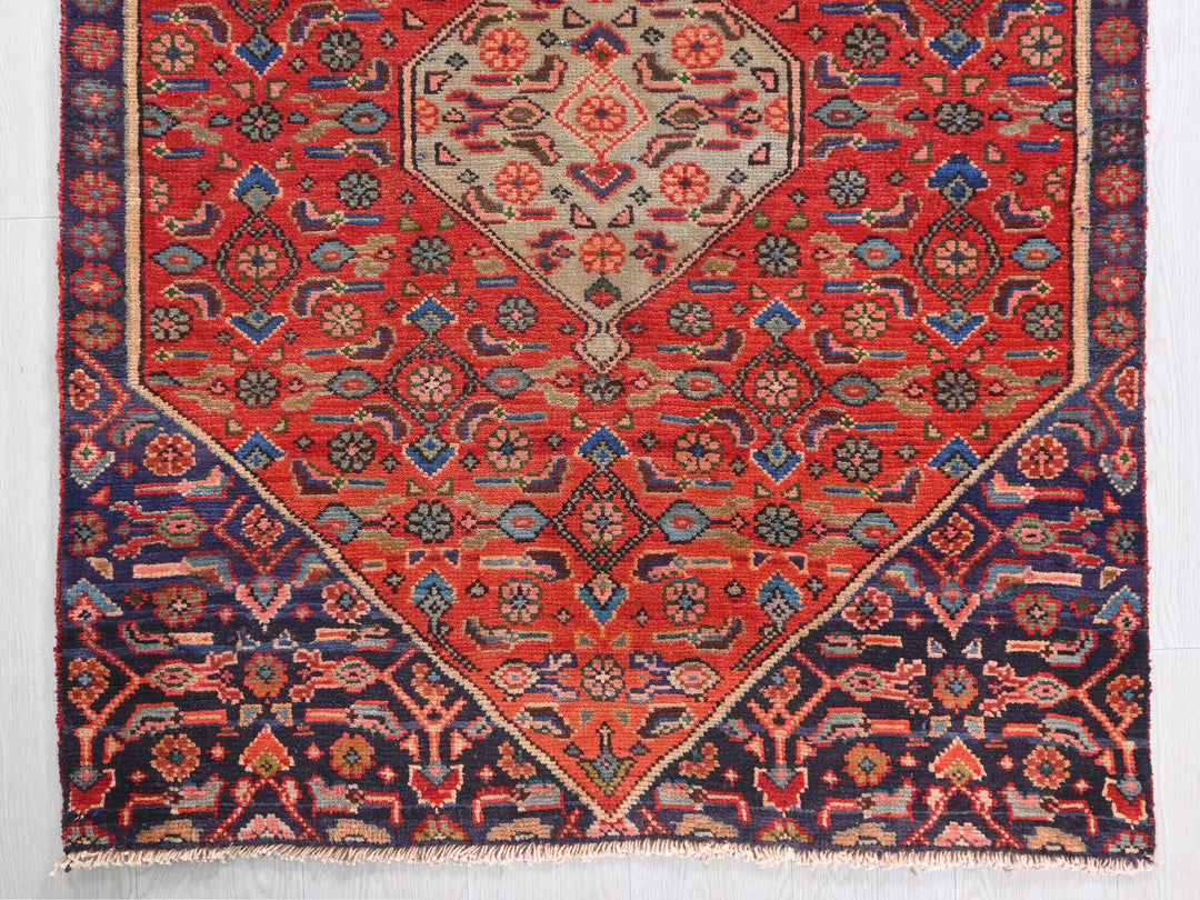 a red rug with a diamond shaped design
