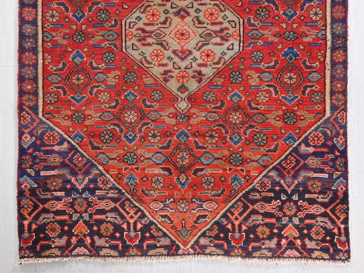 a red rug with a diamond shaped design