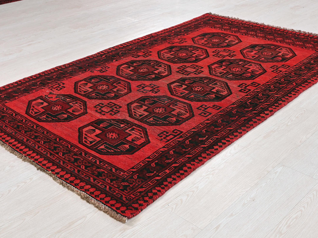 a red and black rug sitting on top of a white floor