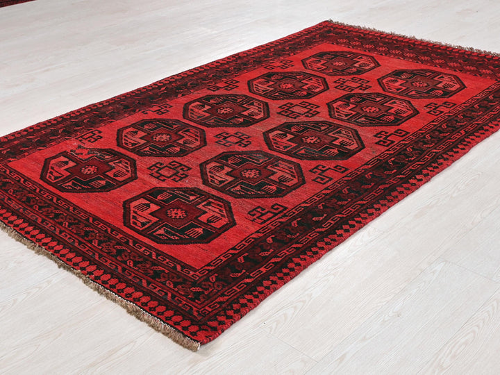 a red and black rug sitting on top of a white floor