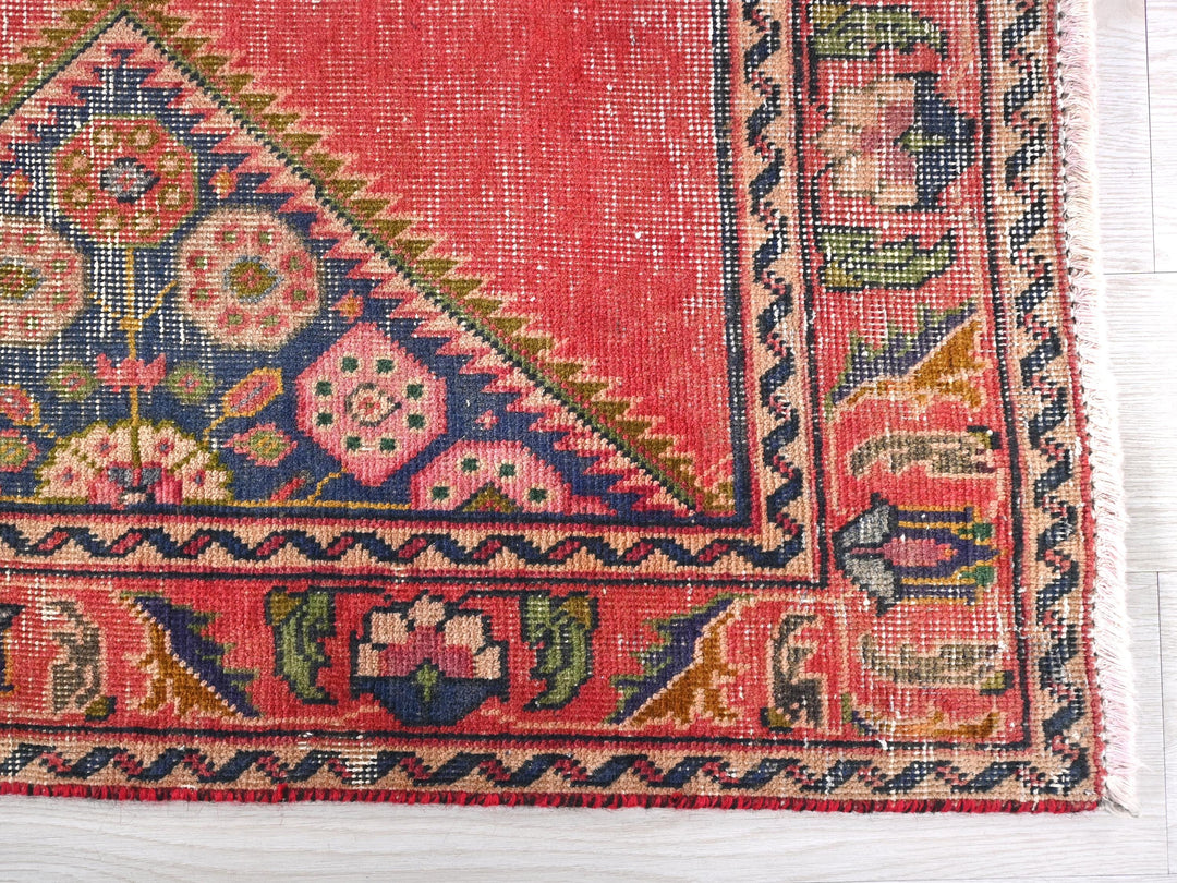 a red rug with a triangle shaped design on it