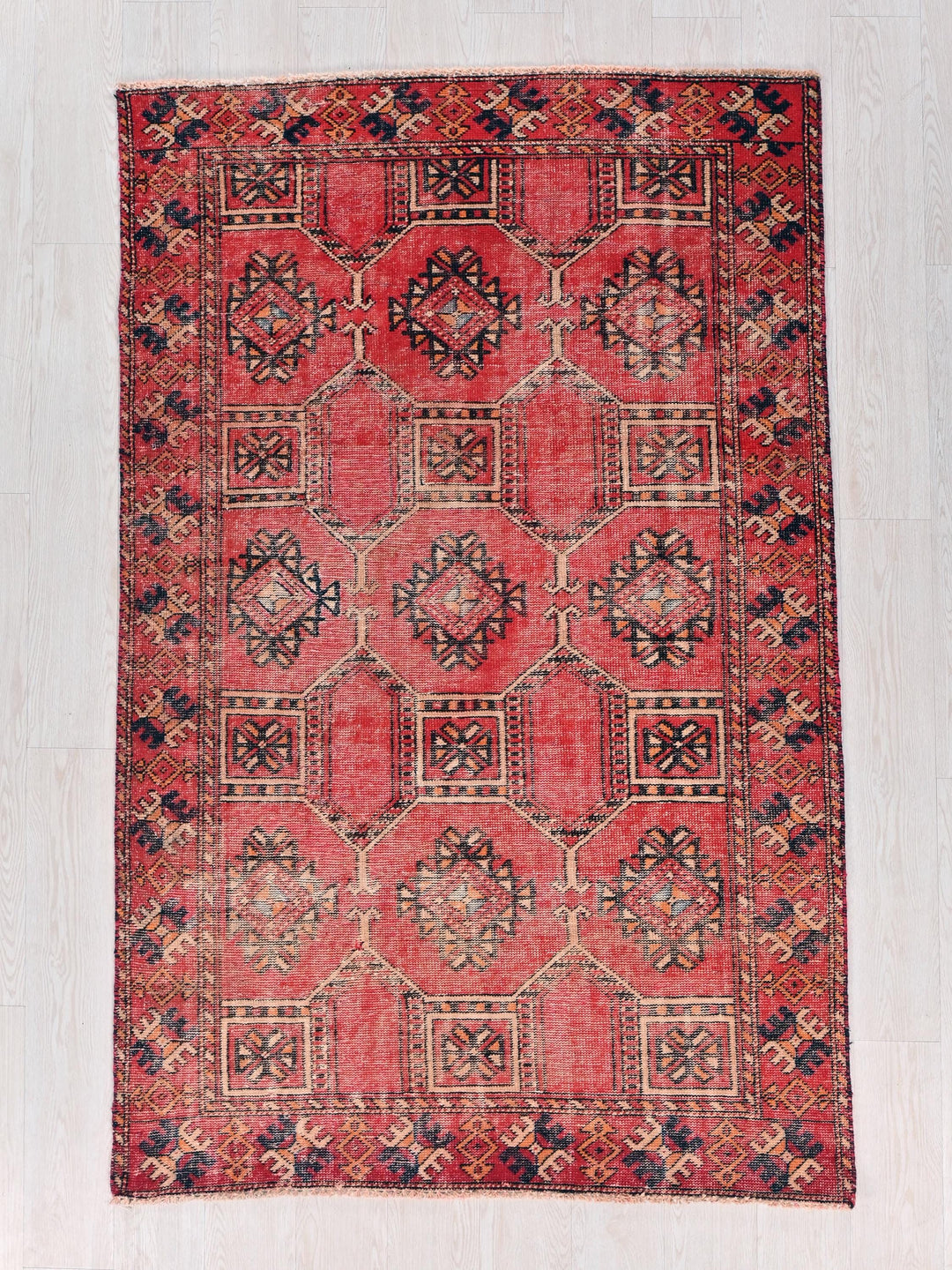 a red rug with a design on the middle of it