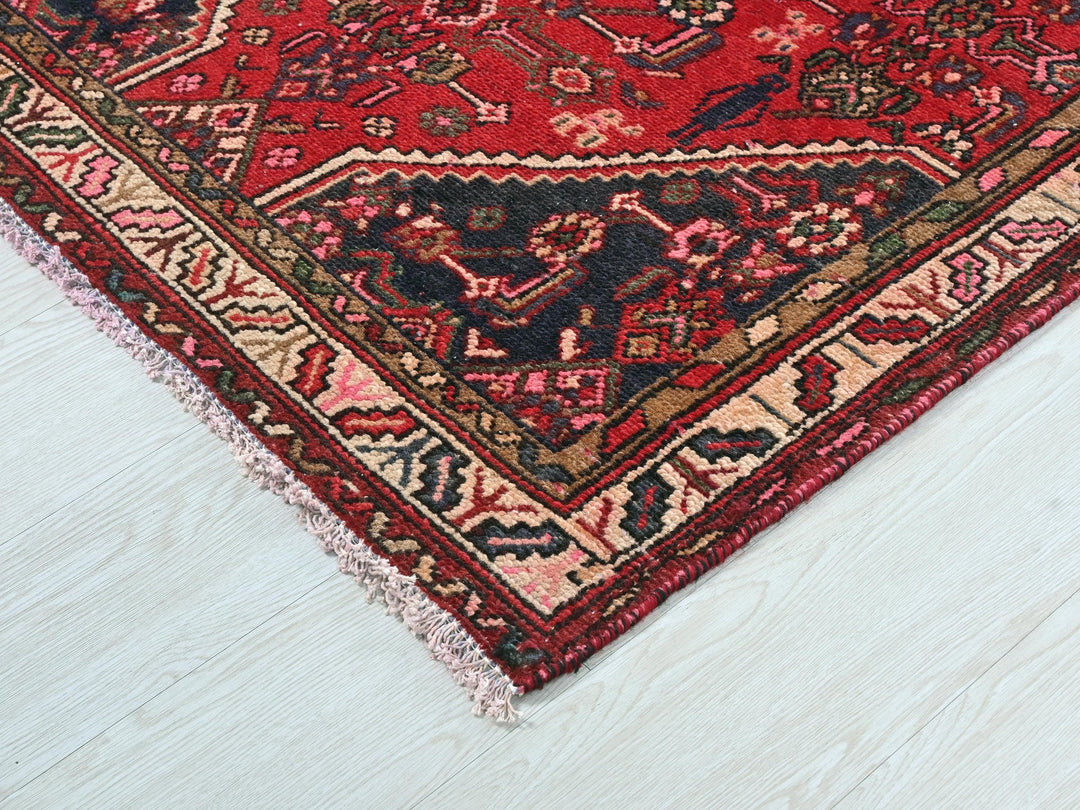 a red oriental rug on a white wooden floor