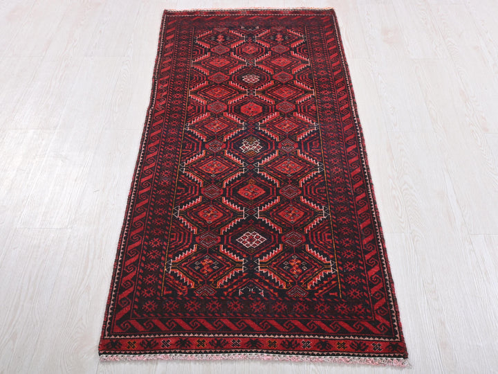 a red and black rug on a white floor
