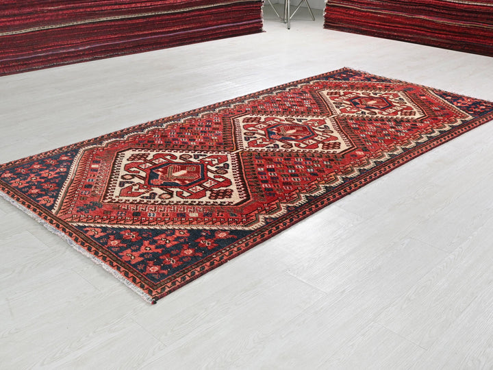 a red and blue rug on a white floor