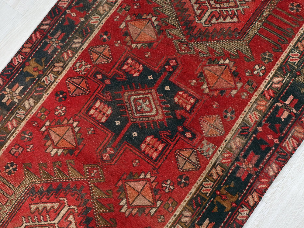 a red oriental rug on a white wooden floor