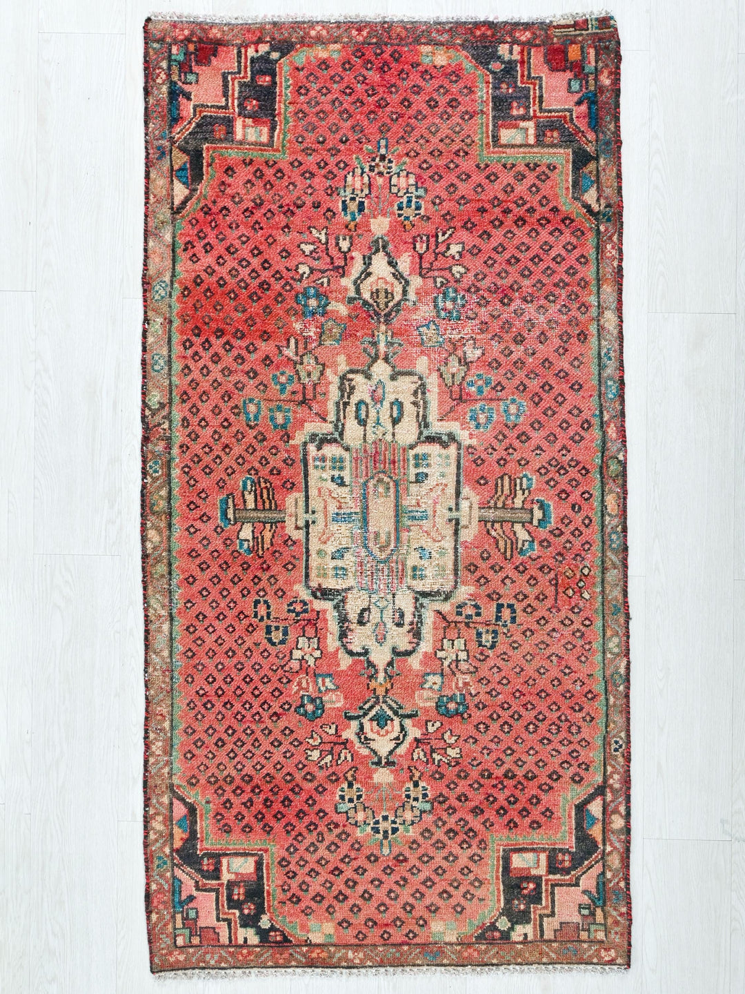 a red rug with a design on the middle of it