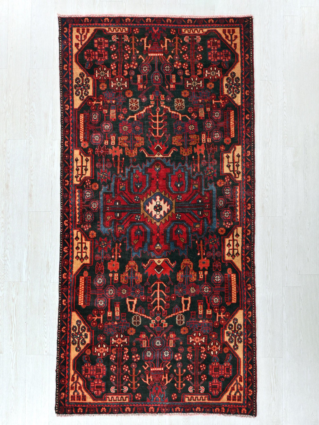 a red and black rug on a white floor