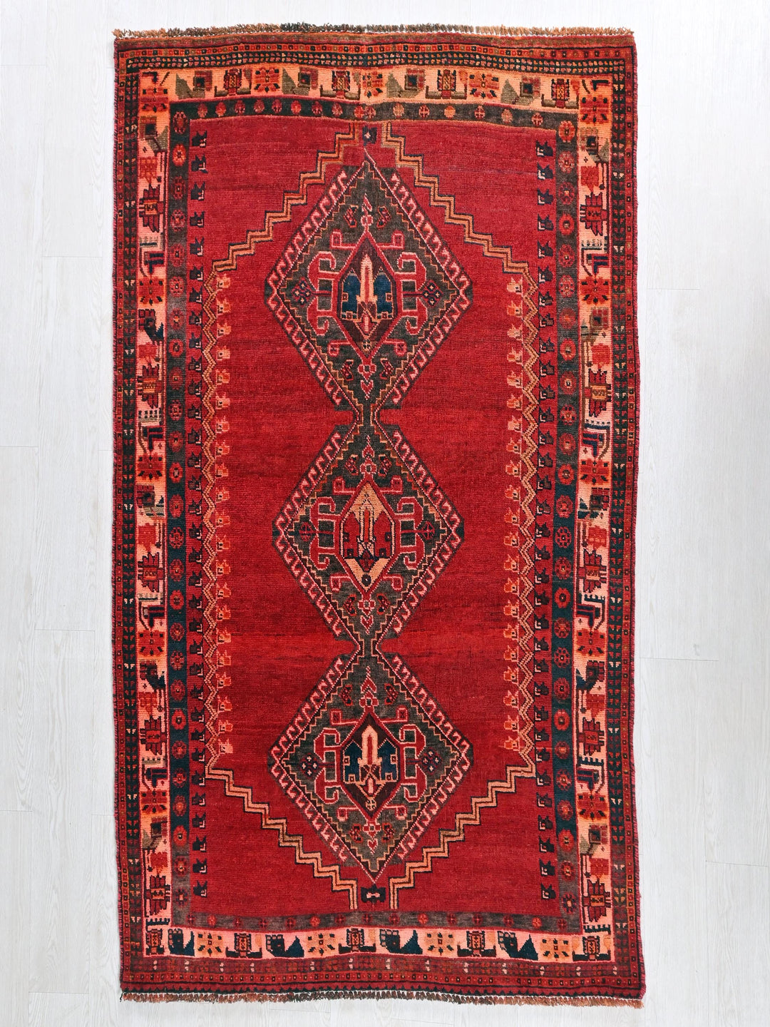 a red rug with a design on the middle of it