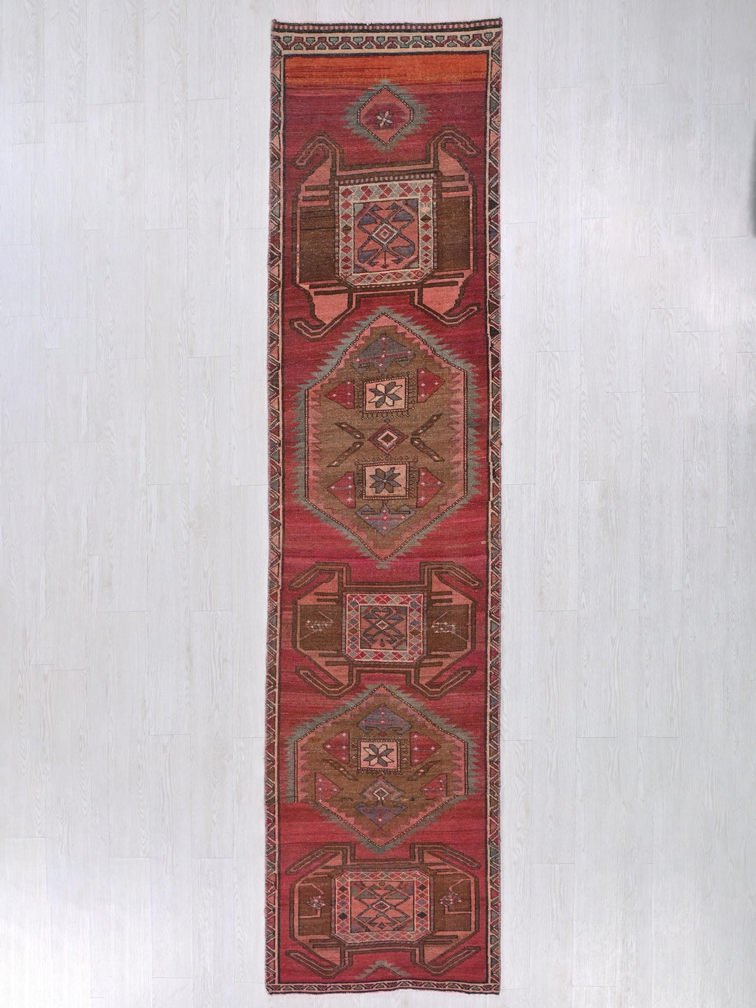a long red rug hanging on a wall