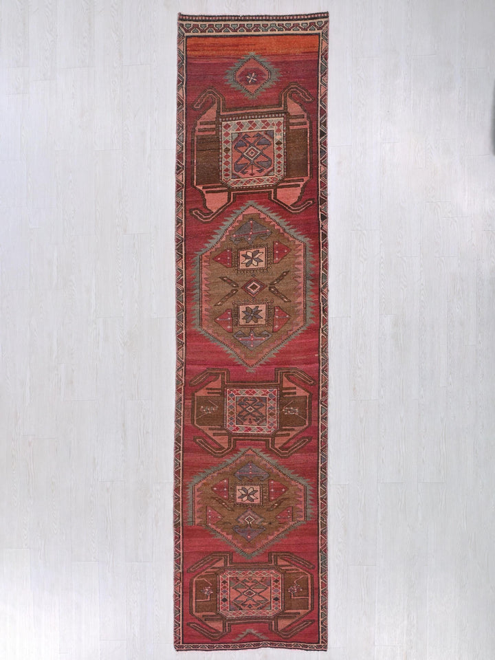 a long red rug hanging on a wall