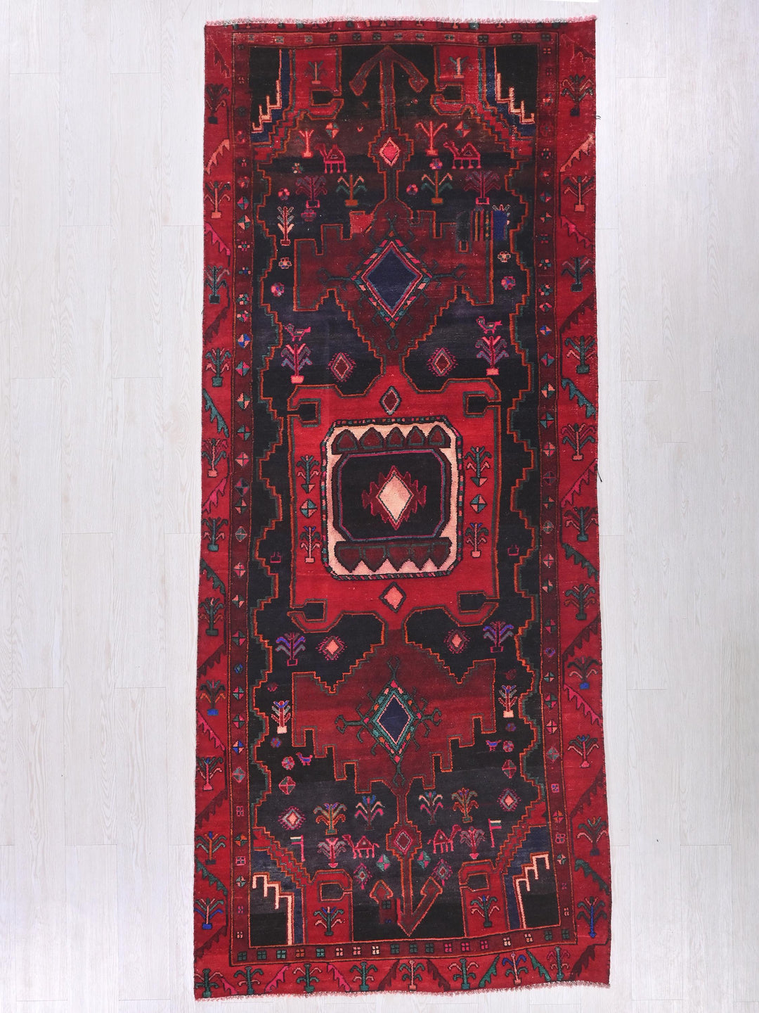 a red rug hanging on a white wall