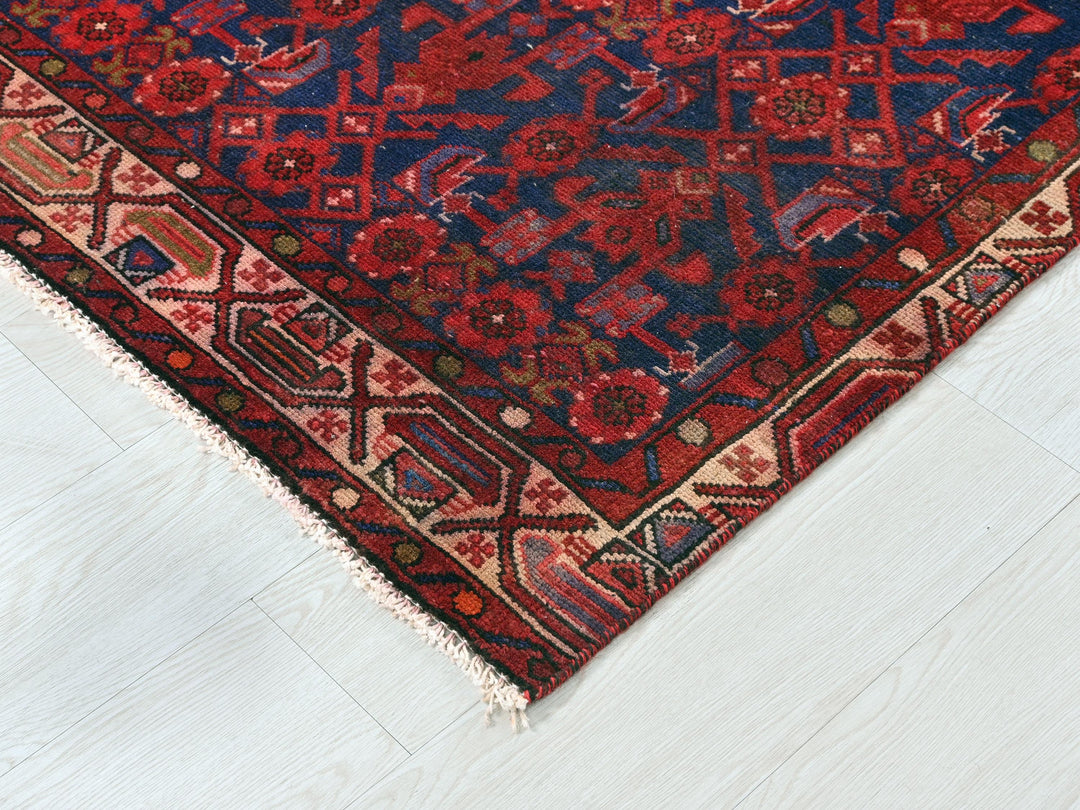 a red and blue rug on a white floor