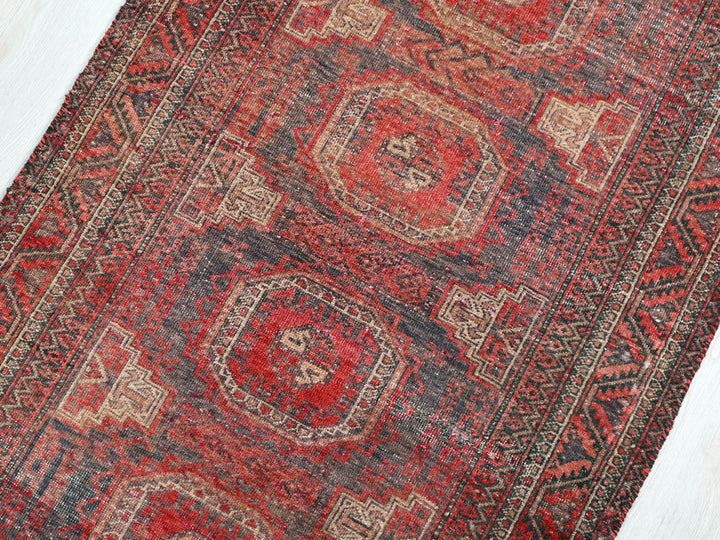 a red and black rug on a white floor