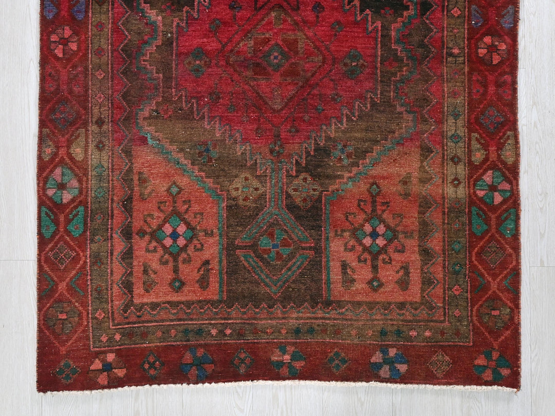 a red rug with a design on the middle of it