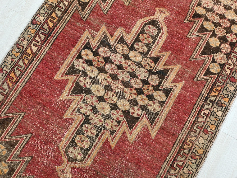 a red rug with a design on the middle of it