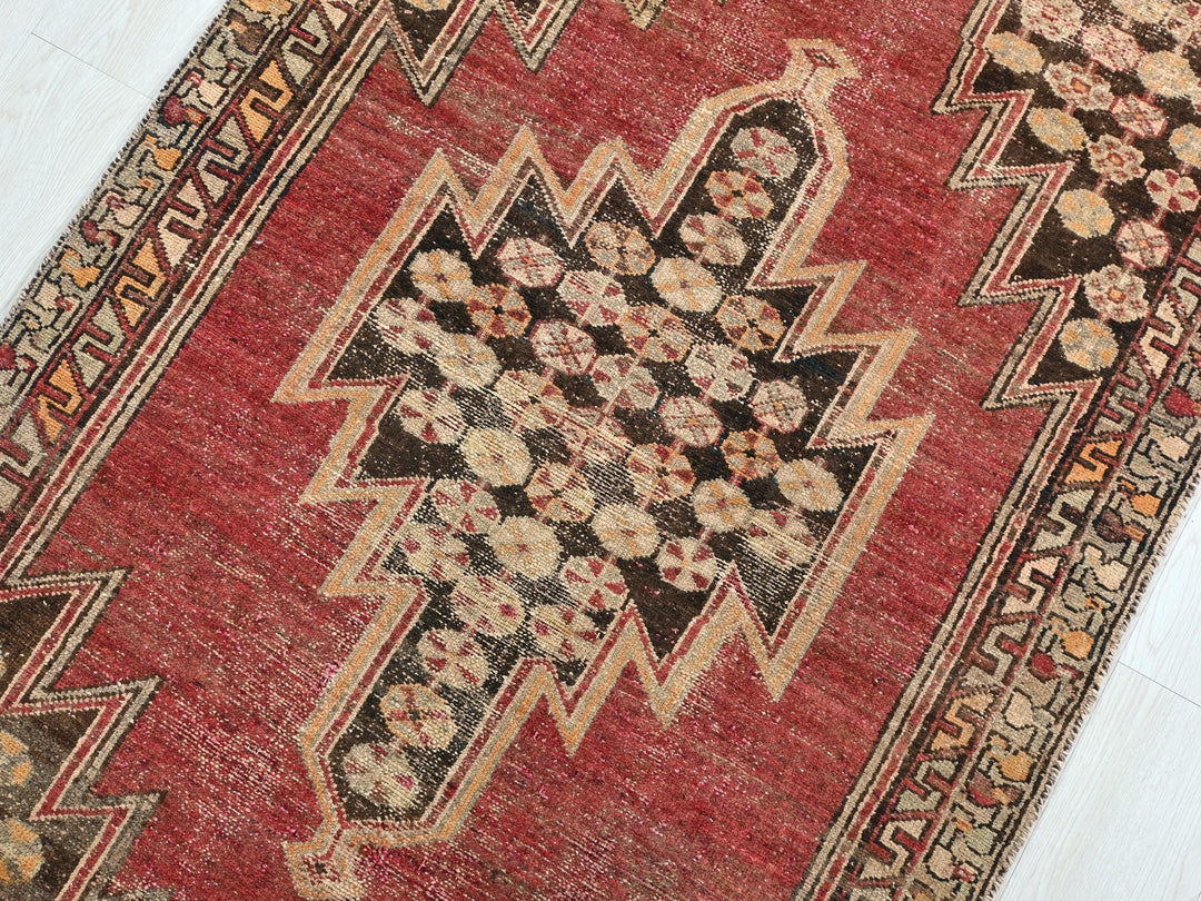 a red rug with a design on the middle of it