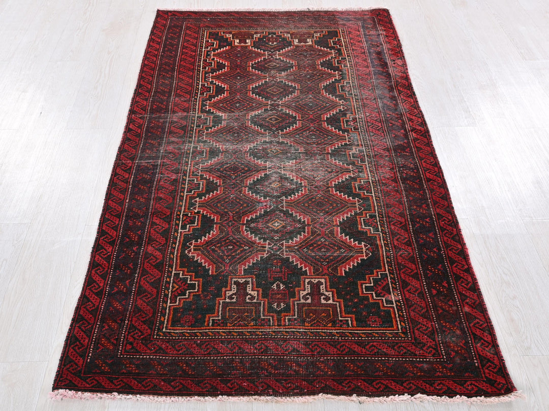 a red and black rug on a white floor