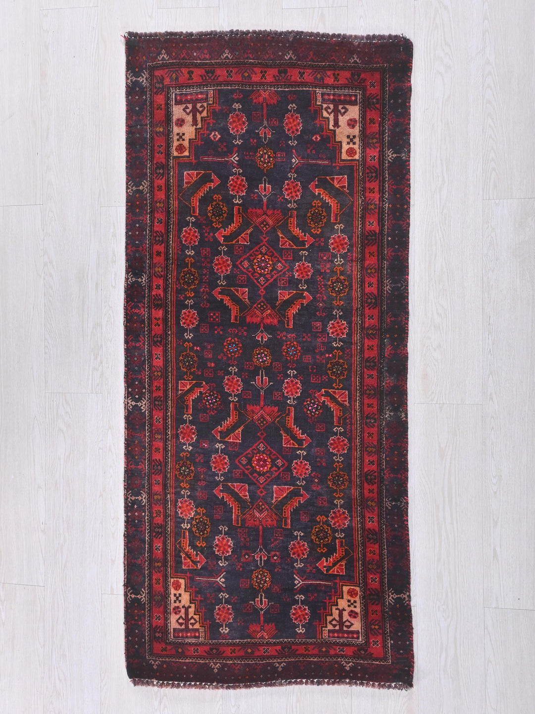 a red and blue rug on a white floor
