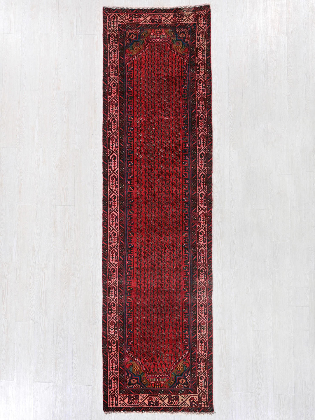 a red rug hanging up against a white wall