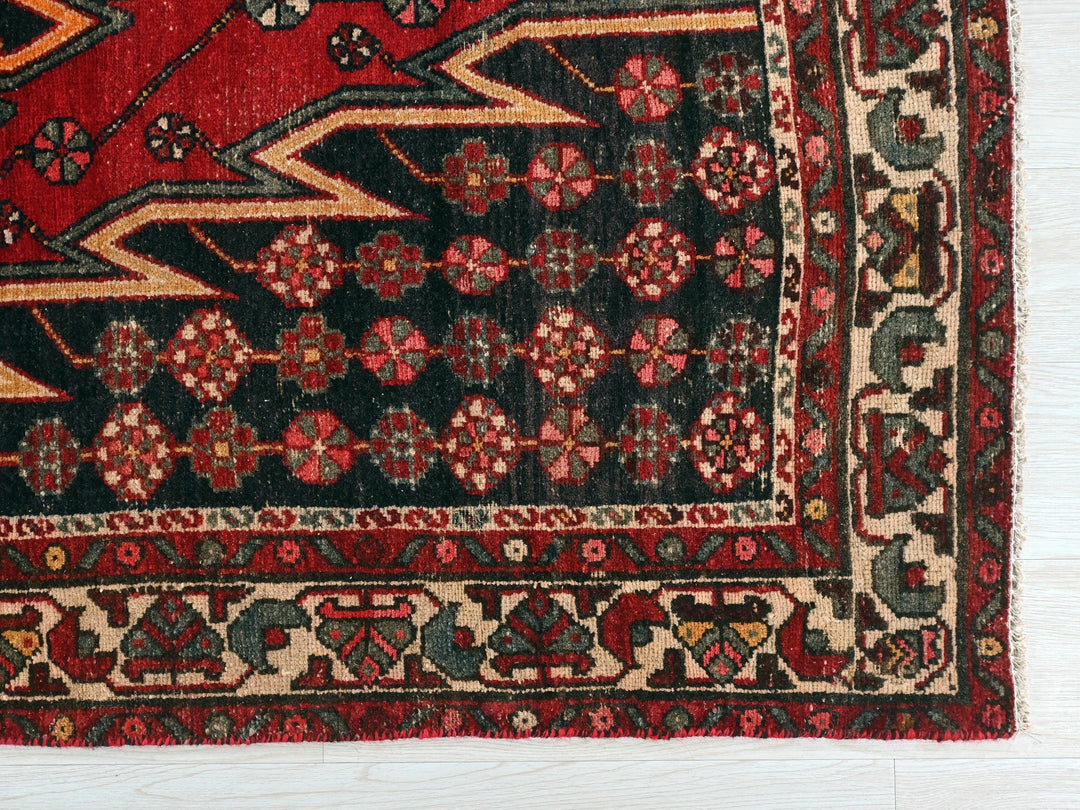 a red and black rug on a white floor