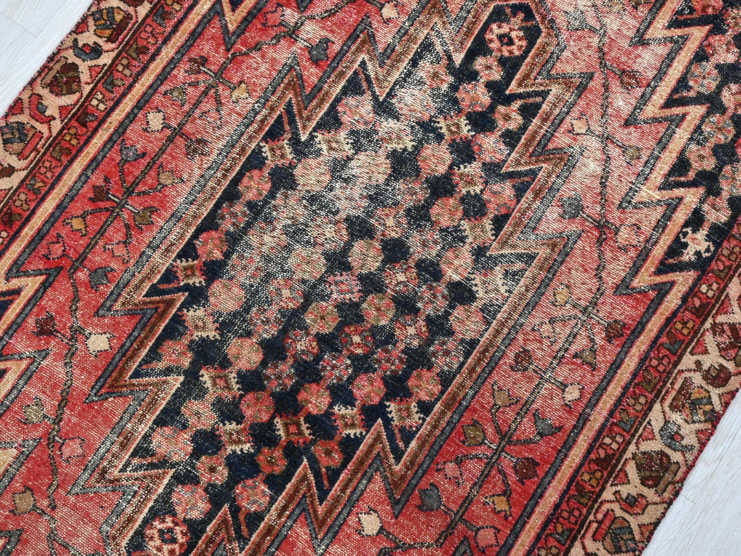 a red and black oriental rug on a wooden floor