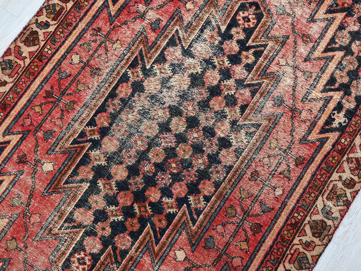 a red and black oriental rug on a wooden floor