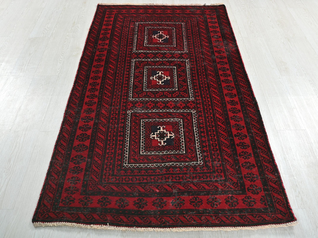 a red and black rug on a white floor
