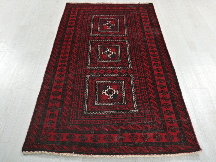 a red and black rug on a white floor