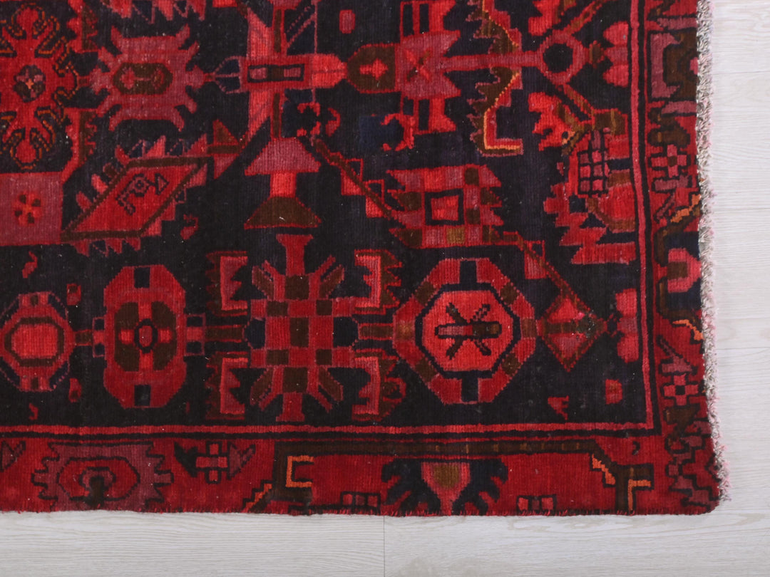 a red and black rug on a white floor