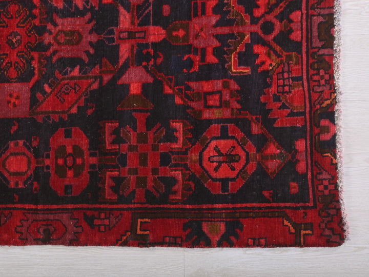a red and black rug on a white floor