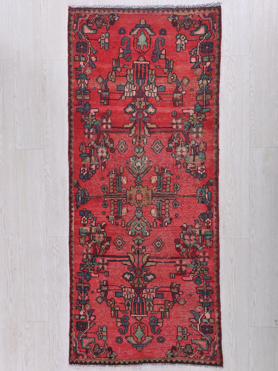 a red rug on a white wooden floor