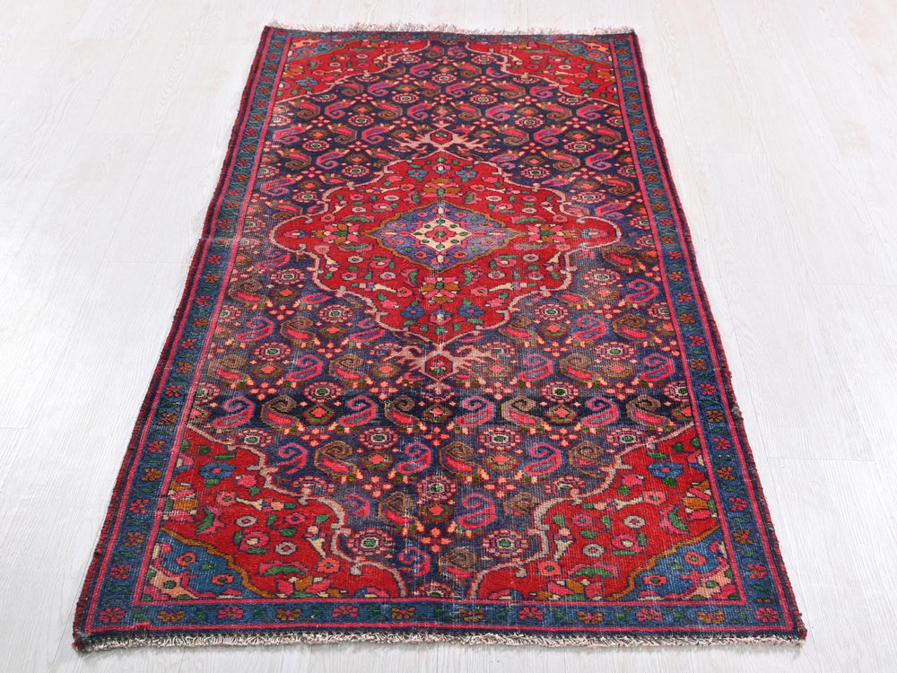 a red and blue rug on a white floor
