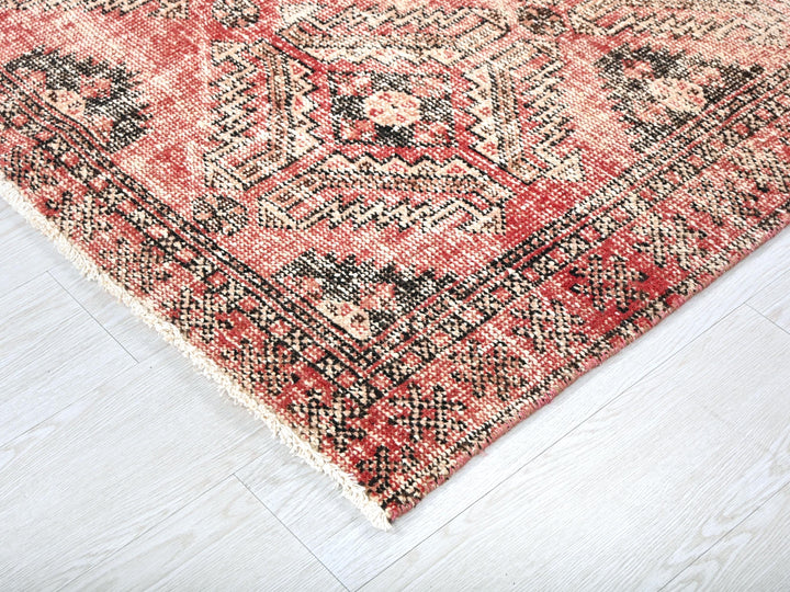 a red and black rug on a white floor