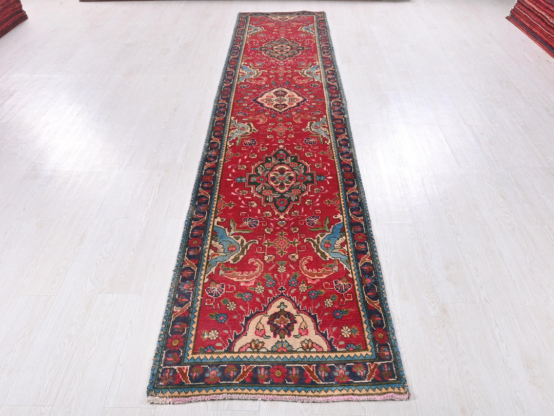 a long red rug on a white floor