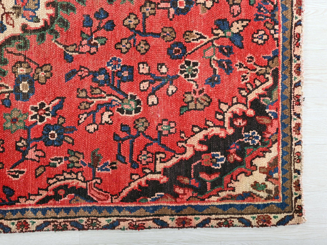 a red rug with a floral design on it