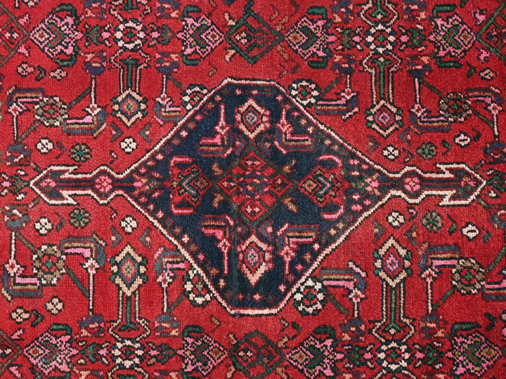 a red rug with a diamond shaped design on it