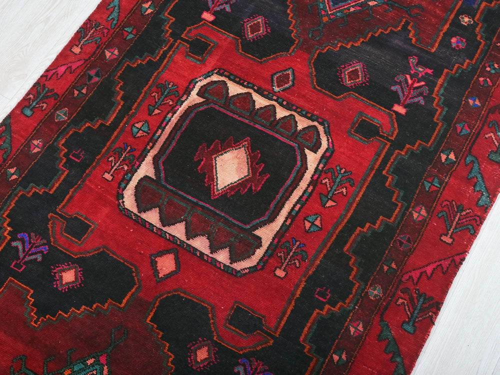 a close up of a red rug on a white floor