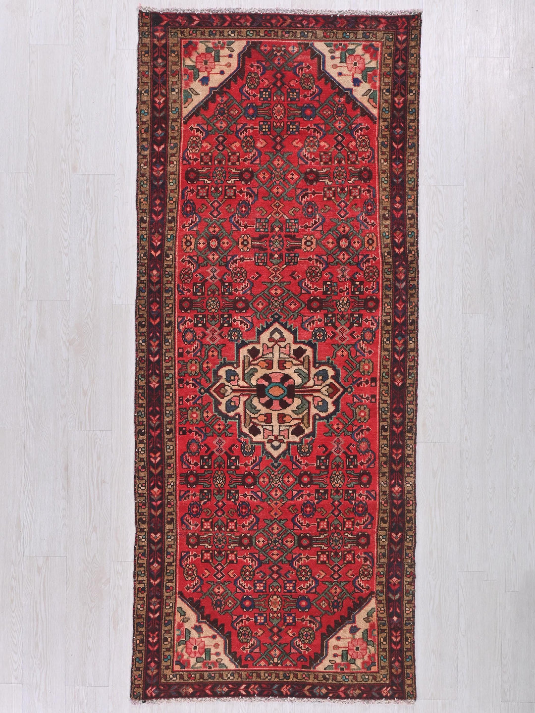 a red rug with a floral design on a white background