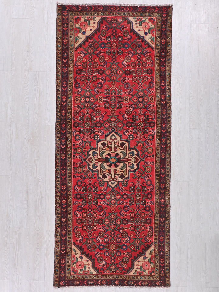 a red rug with a floral design on a white background