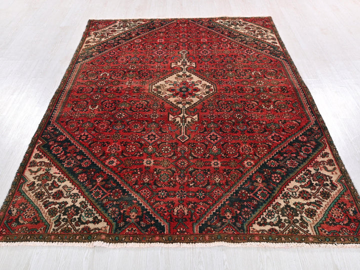 a red rug with a diamond shaped design on it
