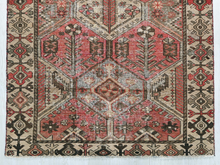 a red and beige rug with a design on it