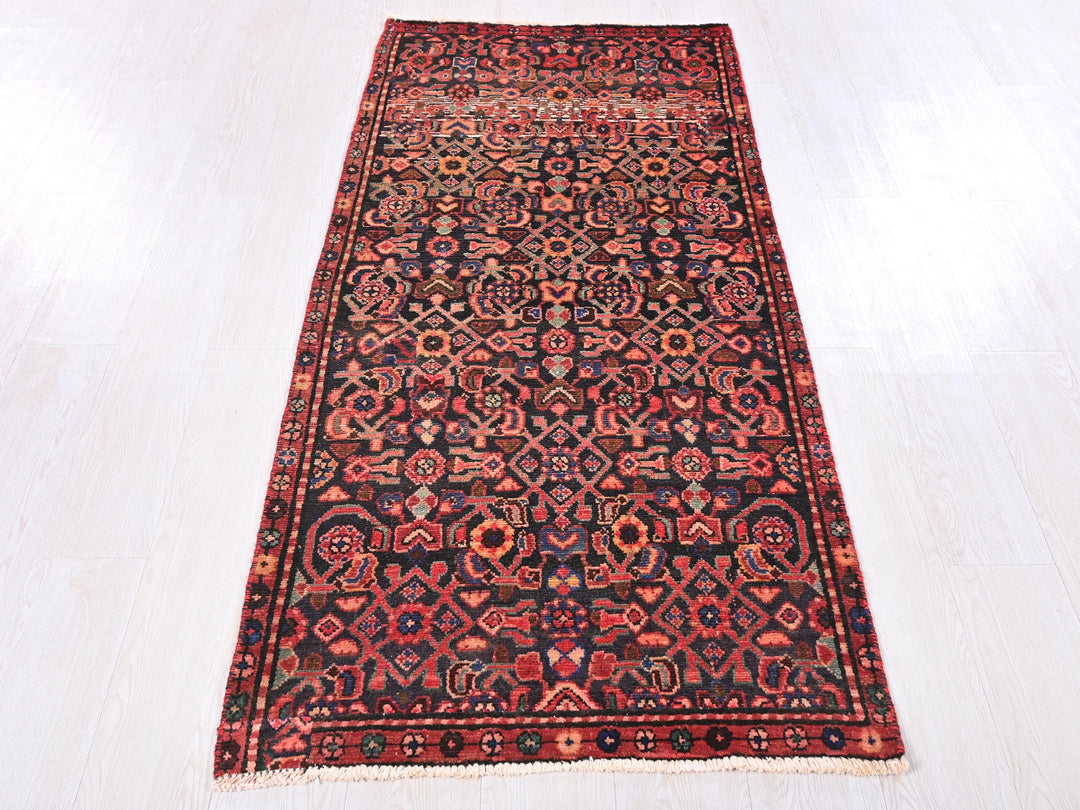 a red and black rug on a white floor