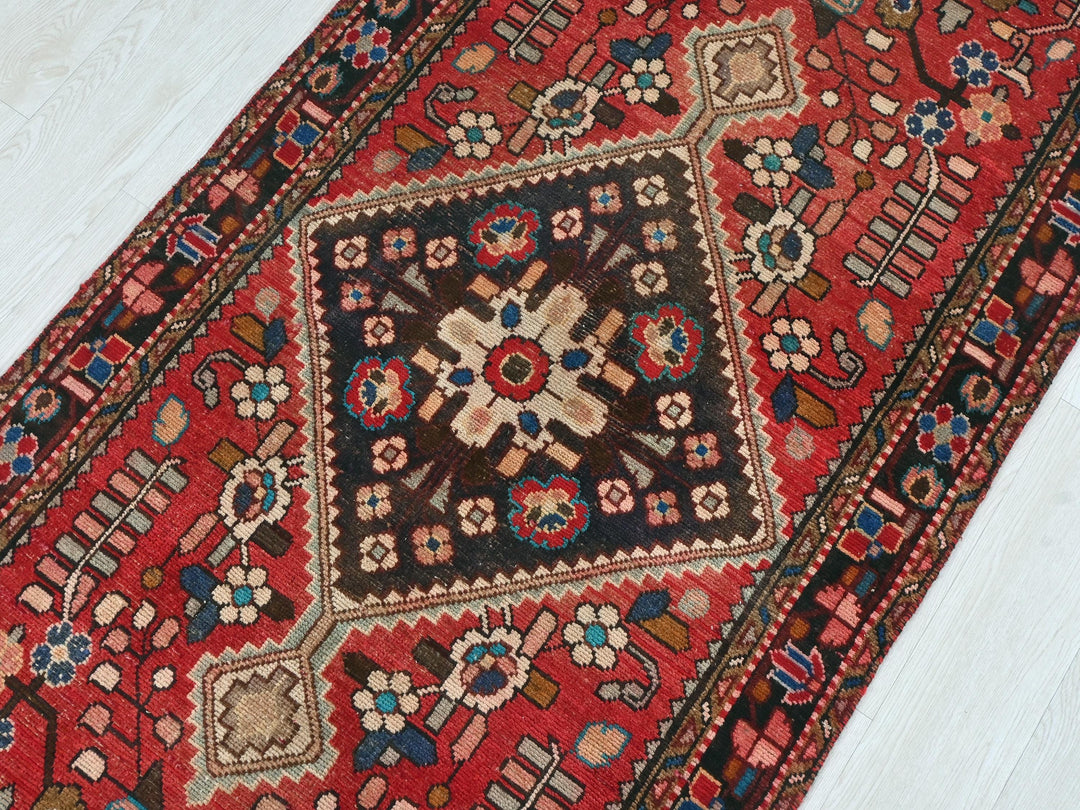 a red oriental rug on a white wooden floor