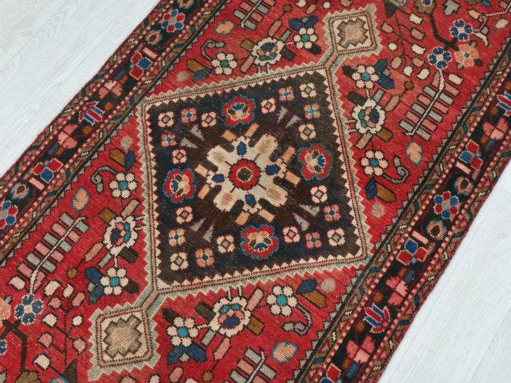a red oriental rug on a white wooden floor