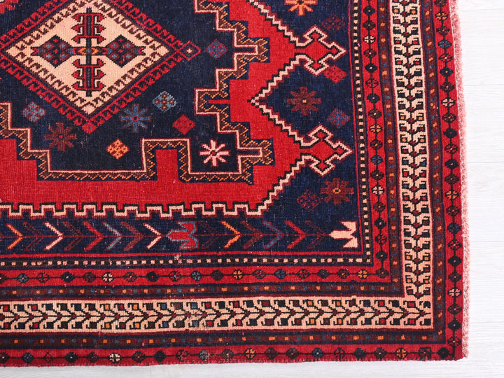a red and blue rug on a white surface