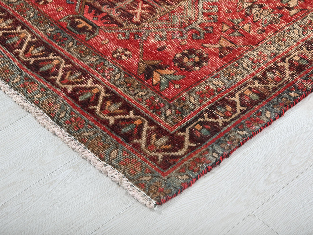 a red oriental rug on a white wooden floor